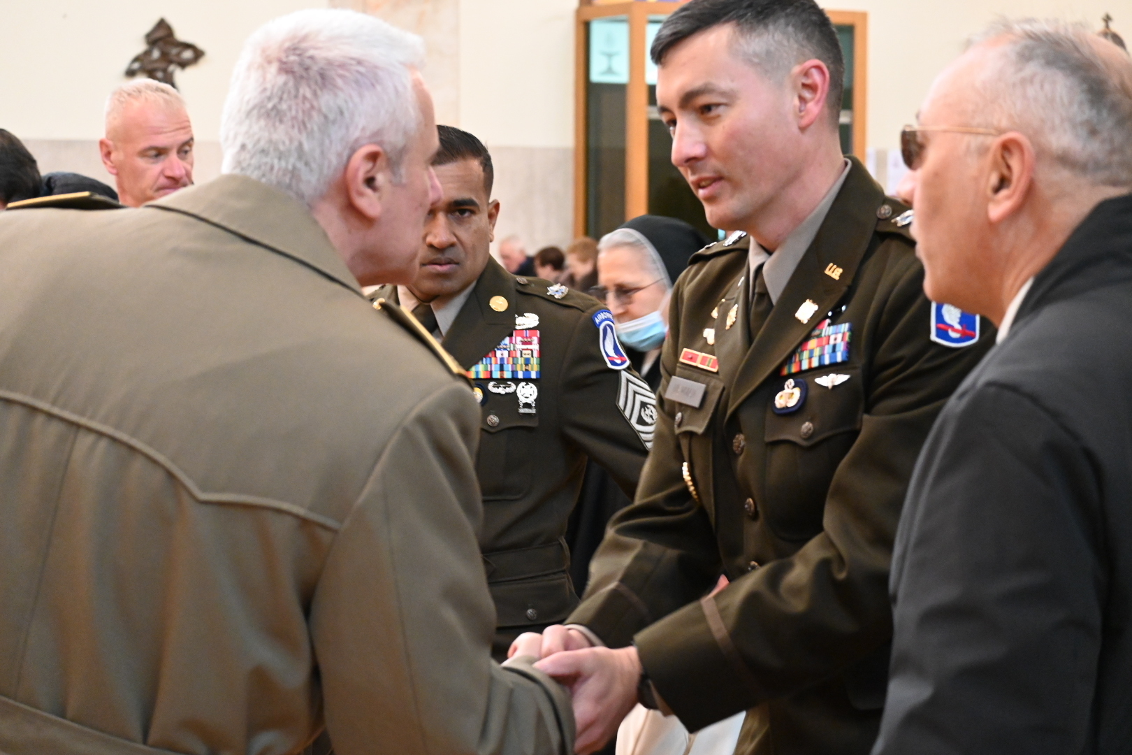 Lt. Col. Anthony Newman and Command Sgt. Maj. Asgar Kamaludeen, command team of the 173rd Brigade Support Battalion, 173rd Airborne Brigade are greeted by members of the Italian Alpini as part of a me