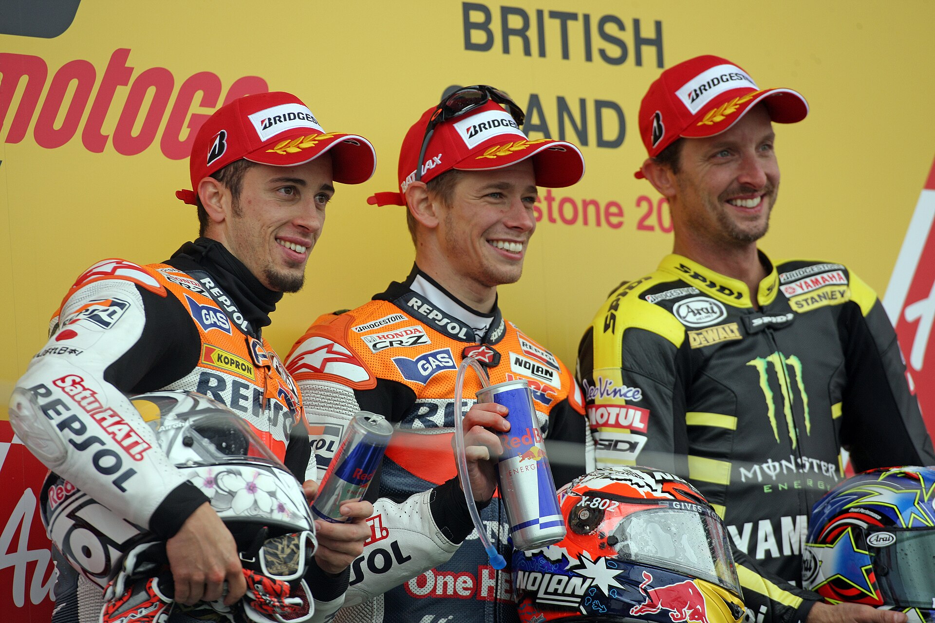 Andrea Dovizioso, Casey Stoner and Colin Edwards, posing for photo's on the podium after finishing in second, first and third place at the 2011 British Grand Prix.