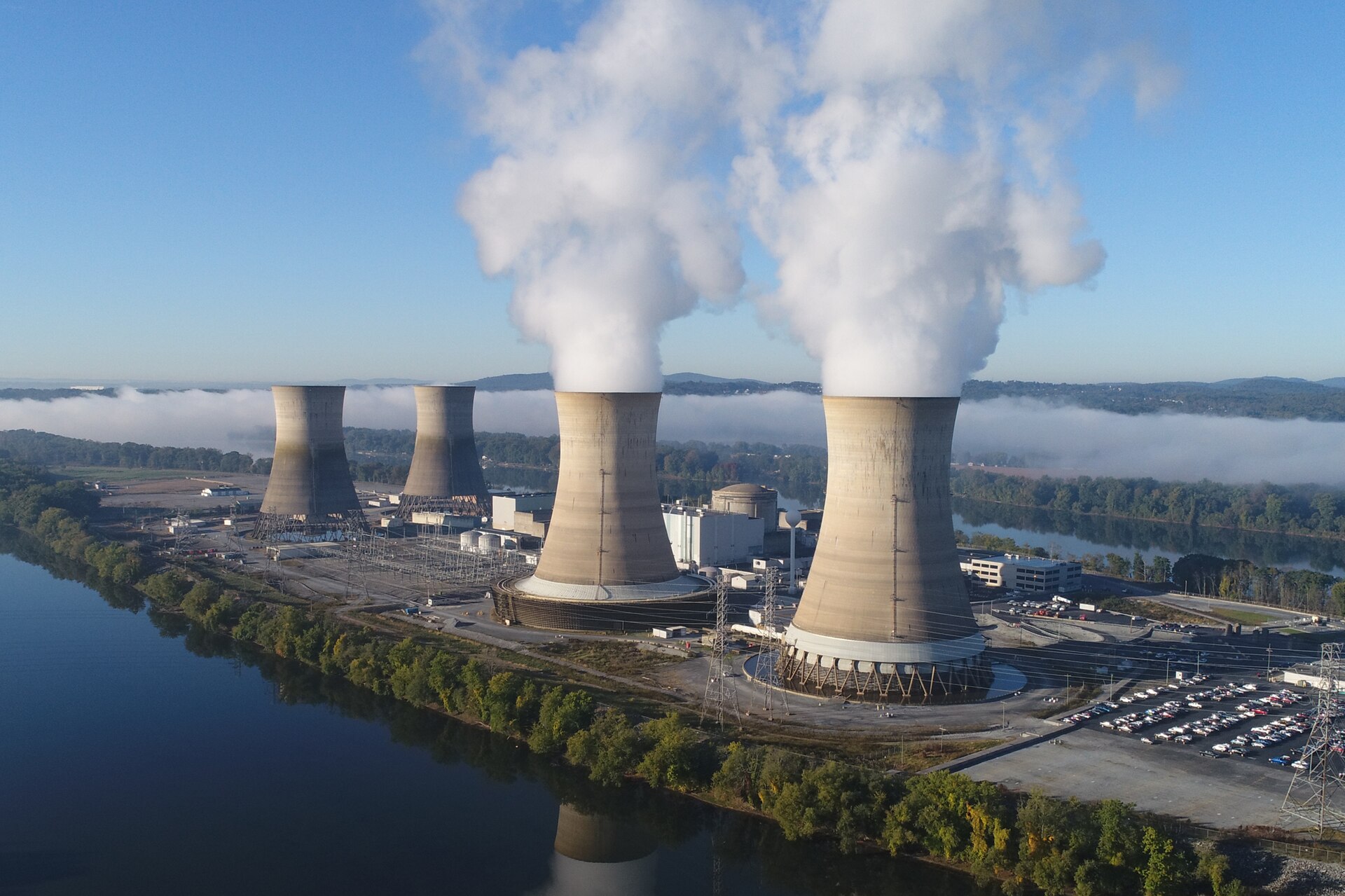 The working cooling towers of Exelon Generation Unit 1 in the foreground are emitting water vapor. The dormant cooling towers are from Unit 2, which was permanently damaged in the 1979 accident.