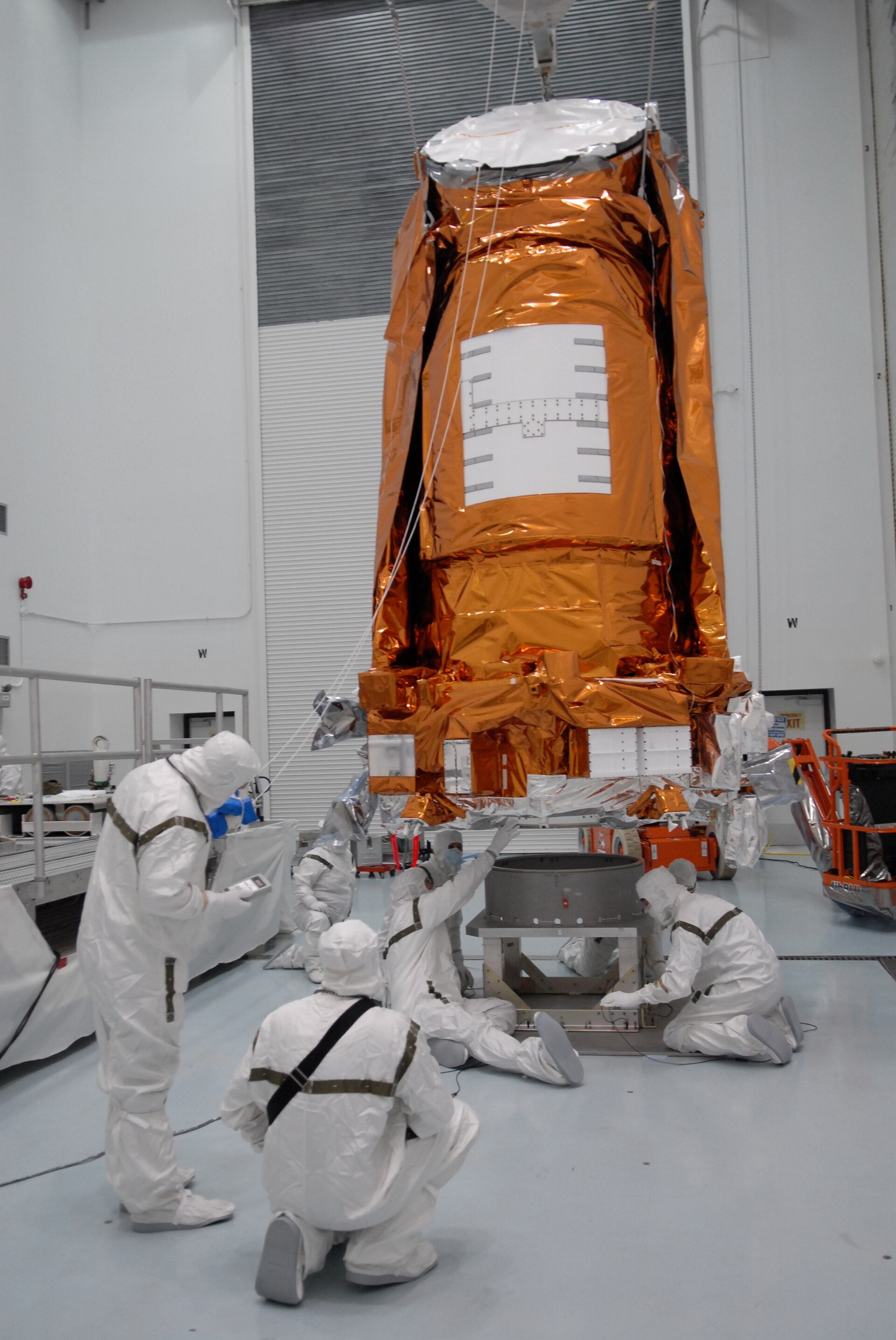 At the Hazardous Processing Facility at Astrotech in Titusville, Fla., workers lift the Kepler spacecraft from a work stand in preparation for mating it to a Delta II third stage. Kepler is designed t
