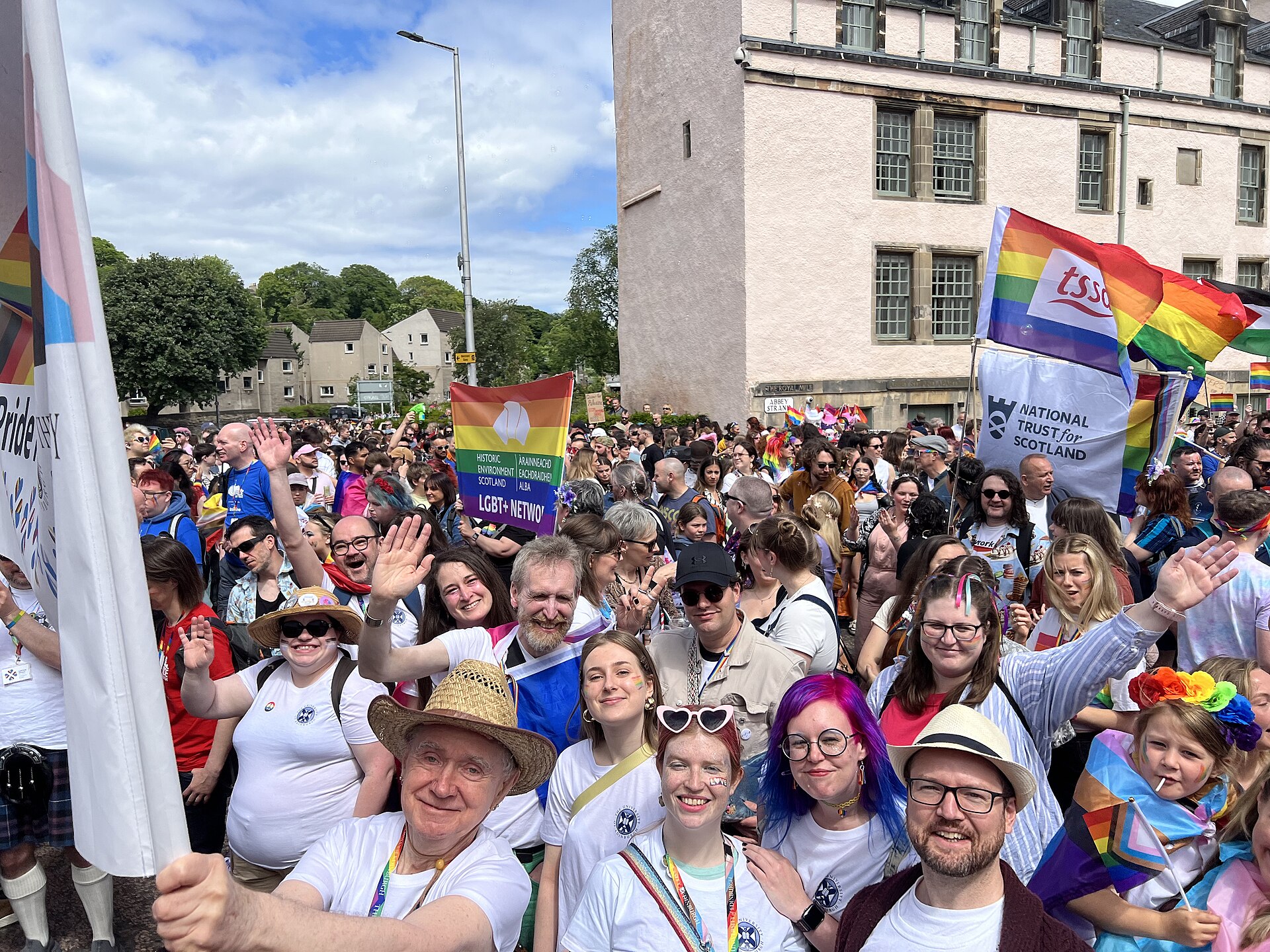 Derek Williams (left) holding Edinburgh University Staff Pride Network banner fronting Pride group