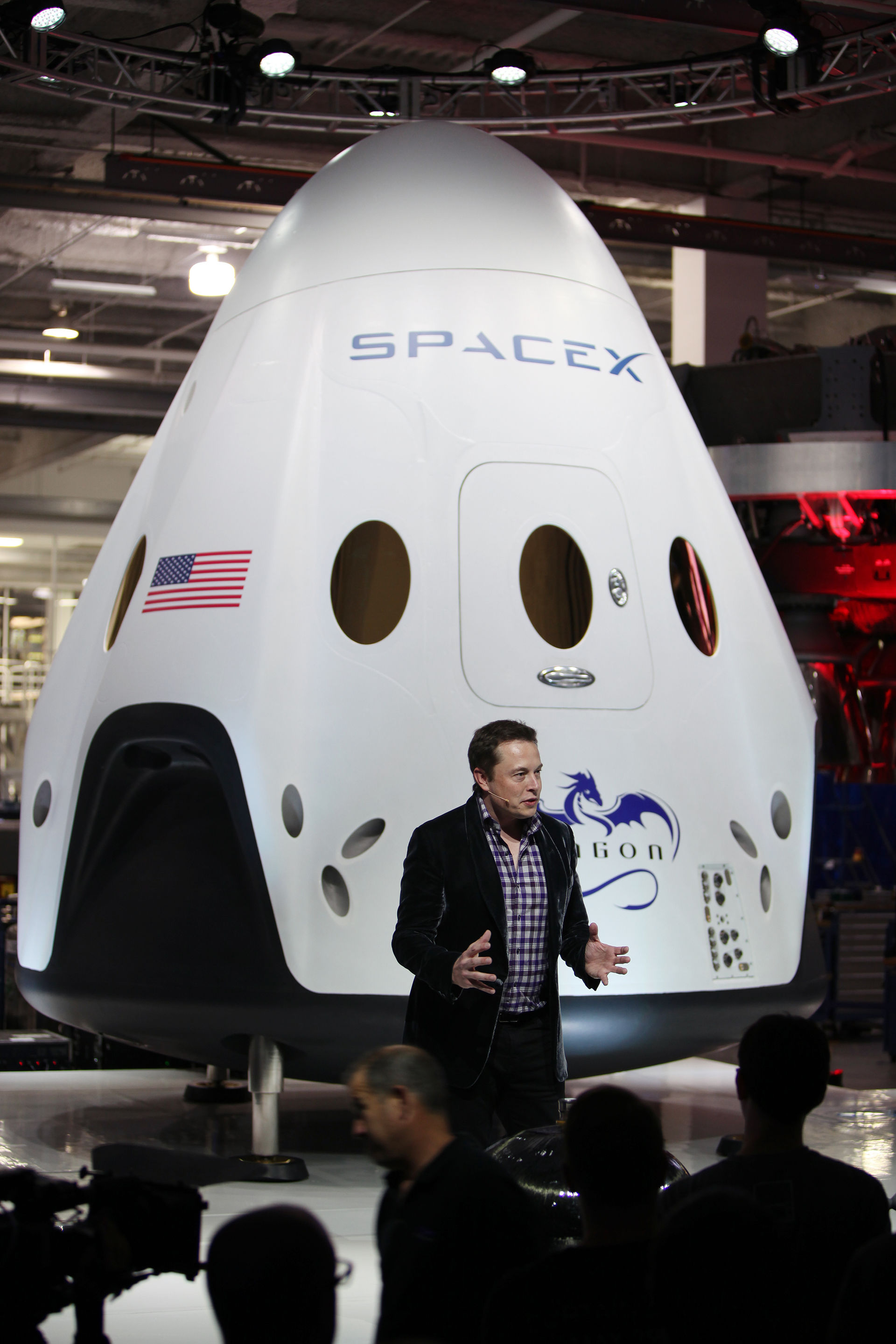 SpaceX CEO and founder Elon Musk unveils the Dragon V2 during a ceremony for the new spacecraft inside SpaceX headquarters in Hawthorne, Calif. The spacecraft is designed to carry people into Earth's